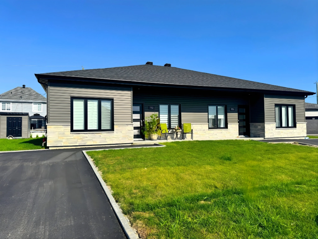 Façade de La Place Haziel à Chicoutimi — revêtement taupe, pierre calcaire, fenêtres noires